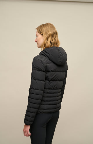 Rückansicht der Frauenschuh Damen-Winterjacke „Leonora“ (Modell STN 010) in der Farbe Black (Schwarz), getragen von einem weiblichen Model. Die Jacke zeigt einen geraden Schnitt mit sportlich-elegantem Design, gefertigt aus wasserabweisendem, atmungsaktivem, feuchtigkeitsregulierendem, elastischem und wärmendem Material. Ideal für Wintersport und Freizeit.