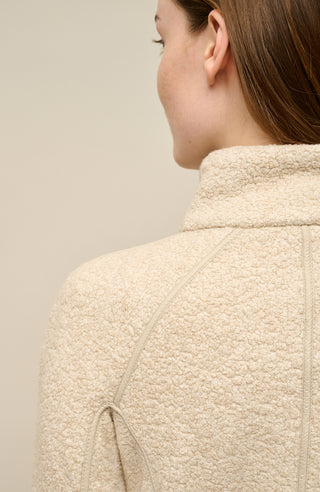 Detailaufnahme des Kragens und Schulterbereichs der Damenjacke „WERA-CT 94-0“ von Frauenschuh in der Farbe „Caramel“. Zu sehen ist der hohe Stehkragen aus luxuriösem Teddyfleece mit Kaschmiranteil. Die Rückseite zeigt die klaren, präzisen Nähte, die den Schulterbereich formen und für eine elegante Passform sorgen. Das Material präsentiert sich flauschig und hochwertig, was den nachhaltigen Charakter der Jacke unterstreicht