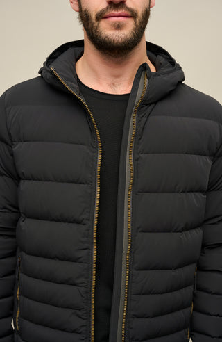 Detailansicht der Frauenschuh Herren Daunen-Winterjacke Lorenzo in Schwarz – Vorderansicht mit Fokus auf den verdeckten Zwei-Wege-Zipper. Die Jacke zeigt ihr modernes Steppdesign, die funktionalen Reißverschlusstaschen und die stilvolle Verarbeitung. Ideal für Winteraktivitäten und kalte Tage, mit warmem, leichtem Tragegefühl.