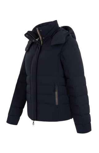 Seitenansicht der Frauenschuh Damen-Daunenjacke Matilde in Dunkelblau – elegante Winterjacke mit hochwertiger Daunenfüllung, gerader Schnitt, verschließbaren Seitentaschen, wasserabweisendes Material, Feuchtigkeitsregulierend und Kapuze die man abnehmen kann, ideal für kalte Wintertage. Die Jacke verfügt über einen Reißverschluss und einer Druckknopfleiste um diese zu schließen
