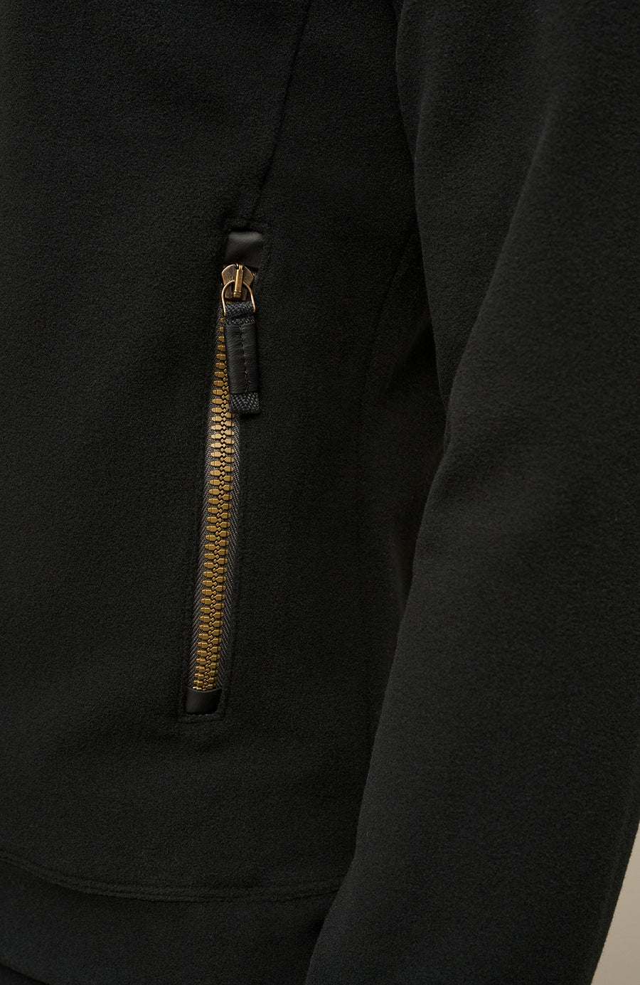 Detailaufnahme der Herrenjacke „Oliver-BF 01-0“ von Frauenschuh in der Farbe „Black“, einem tiefen, eleganten Schwarz. Die Nahaufnahme zeigt präzise Verarbeitungsdetails wie eine saubere Nahtführung, den hochwertigen Reißverschluss und eine Seitentasche. Das technische, glatte Material wirkt funktional und strapazierfähig, mit einer leicht strukturierten Oberfläche. Die Detailansicht hebt die exzellente Verarbeitung und das puristische, hochwertige Design hervor