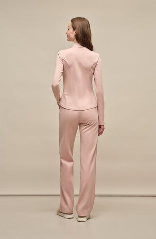 Model trägt die Damen-Powerstretch-Hose „Inga“ in der Farbe Dusty Rose – Rückansicht, zeigt die gerade geschnittene Hose ohne Taschen und Reißverschlüsse, mit elastischem Bund und einem schlichten, funktionalen Design für maximalen Tragekomfort und Bewegungsfreiheit
