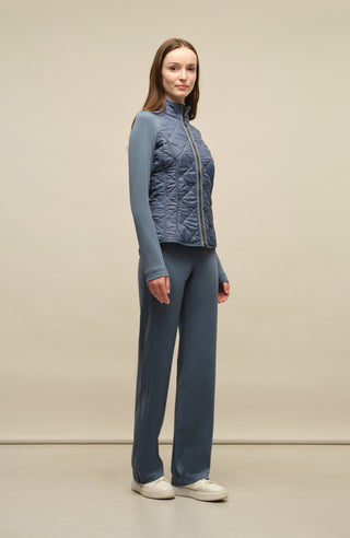 Model trägt die Damen-Powerstretch-Hose „Inga“ in der Farbe Denim – seitliche Perspektive, zeigt die gerade geschnittene Hose ohne Taschen und Reißverschlüsse, mit elastischem Bund und schlichtem Design für optimale Bewegungsfreiheit und Komfort