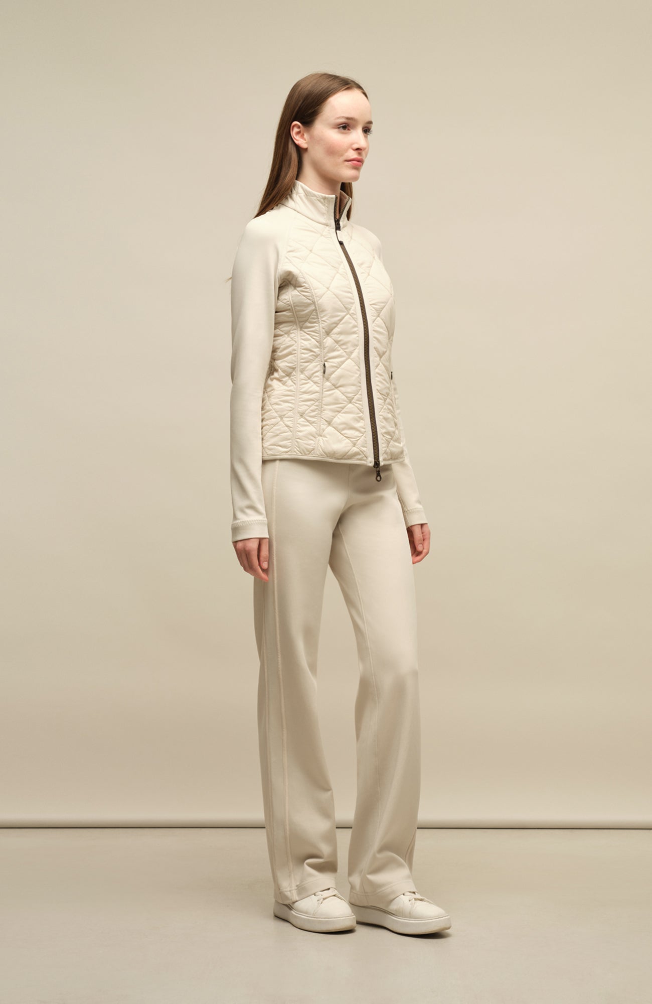 Model trägt die Damen-Powerstretch-Hose „Inga“ in der Farbe Sandstone – seitliche Ansicht, zeigt den geraden, leggingsähnlichen Schnitt ohne Taschen und Reißverschlüsse, mit elastischem Bund; ideal für sportliche Aktivitäten und den Alltag in Frühling und Sommer