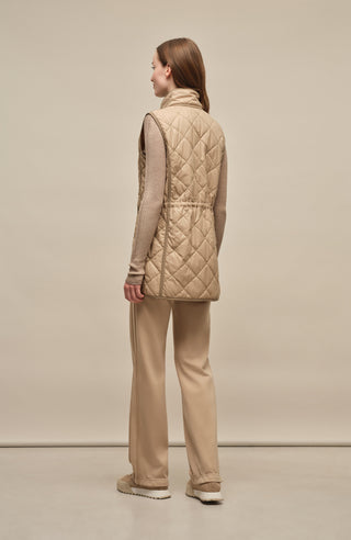 Model trägt die Damen-Powerstretch-Hose „Inga“ in der Farbe Savannah – Seitenansicht; gerade geschnittene, leggingsähnliche Hose ohne Taschen und Reißverschlüsse, mit elastischem Bund und weichem, dehnbarem Material für hohen Tragekomfort bei Outdoor-Aktivitäten und im Alltag