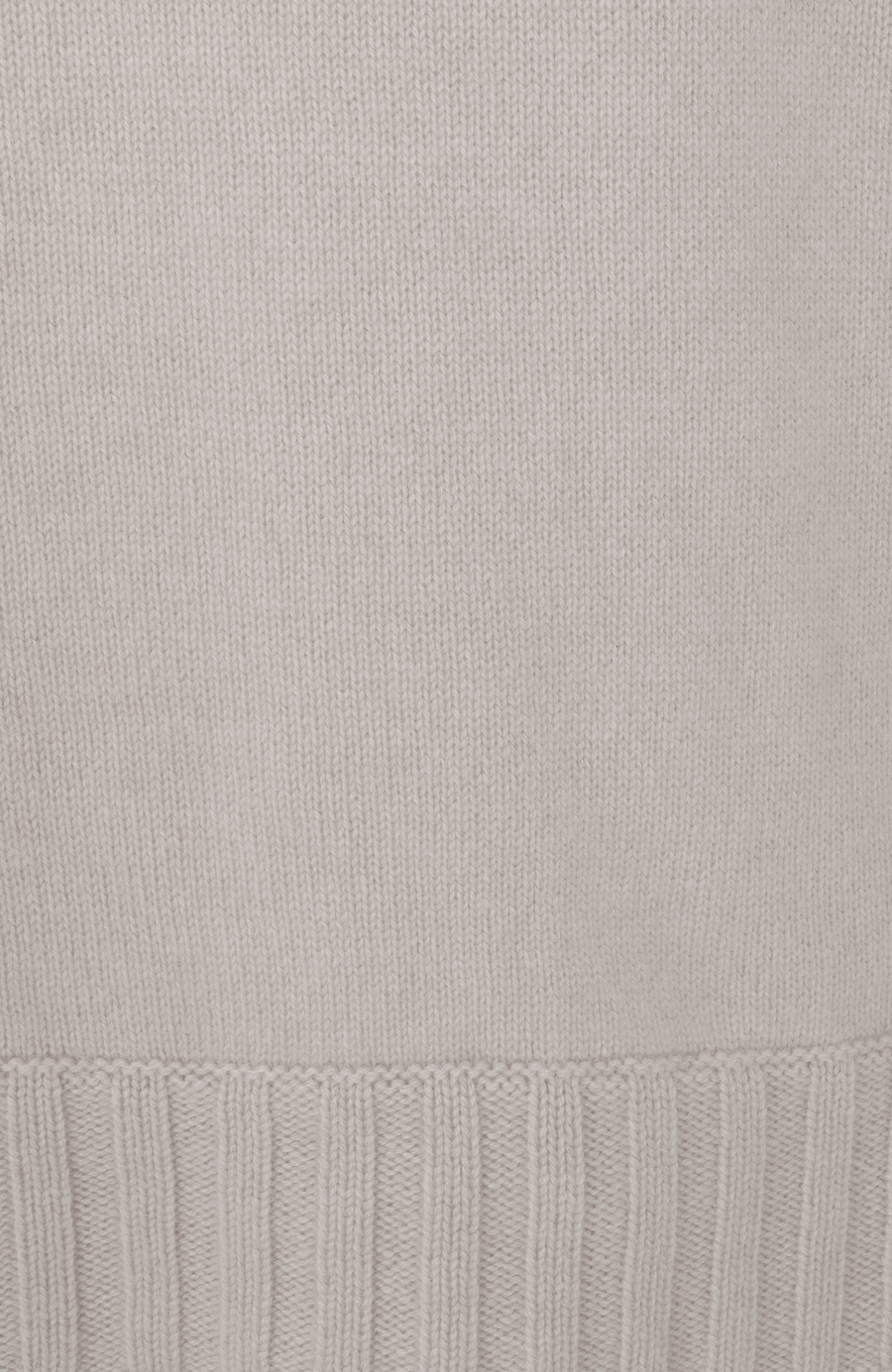 Detailaufnahme des Saums und unteren Bereichs eines Herren-Kaschmirpullovers von Frauenschuh, Modell „Aiden“ (Artikelnummer WS_10-0) in der Farbe Beige. Der fein gestrickte Rippbündchen-Saum aus 100 % Kaschmir hebt sich durch seine robuste Struktur vom glatt gestrickten Körper des Pullovers ab. Das Bild zeigt die hochwertige Verarbeitung und die luxuriöse Materialqualität, typisch für die alpine Premium-Mode von Frauenschuh.