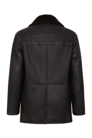 Dunkelbraune Cabanjacke aus weichem Lammfell mit Fellkragen, beidseitig tragbar, markanten Hornknöpfen und ikonischer Schließe – moderner, komfortabler Stil.