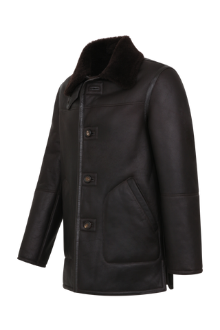 Dunkelbraune Cabanjacke aus weichem Lammfell mit Fellkragen, beidseitig tragbar, markanten Hornknöpfen und ikonischer Schließe – moderner, komfortabler Stil.