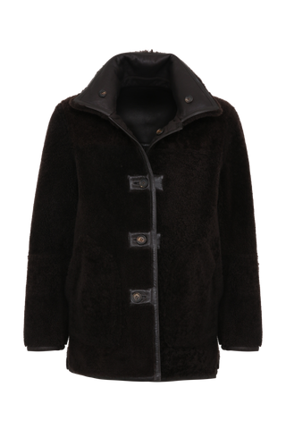 Dunkelbraune Cabanjacke aus weichem Lammfell mit Fellkragen, beidseitig tragbar, markanten Hornknöpfen und ikonischer Schließe – moderner, komfortabler Stil.