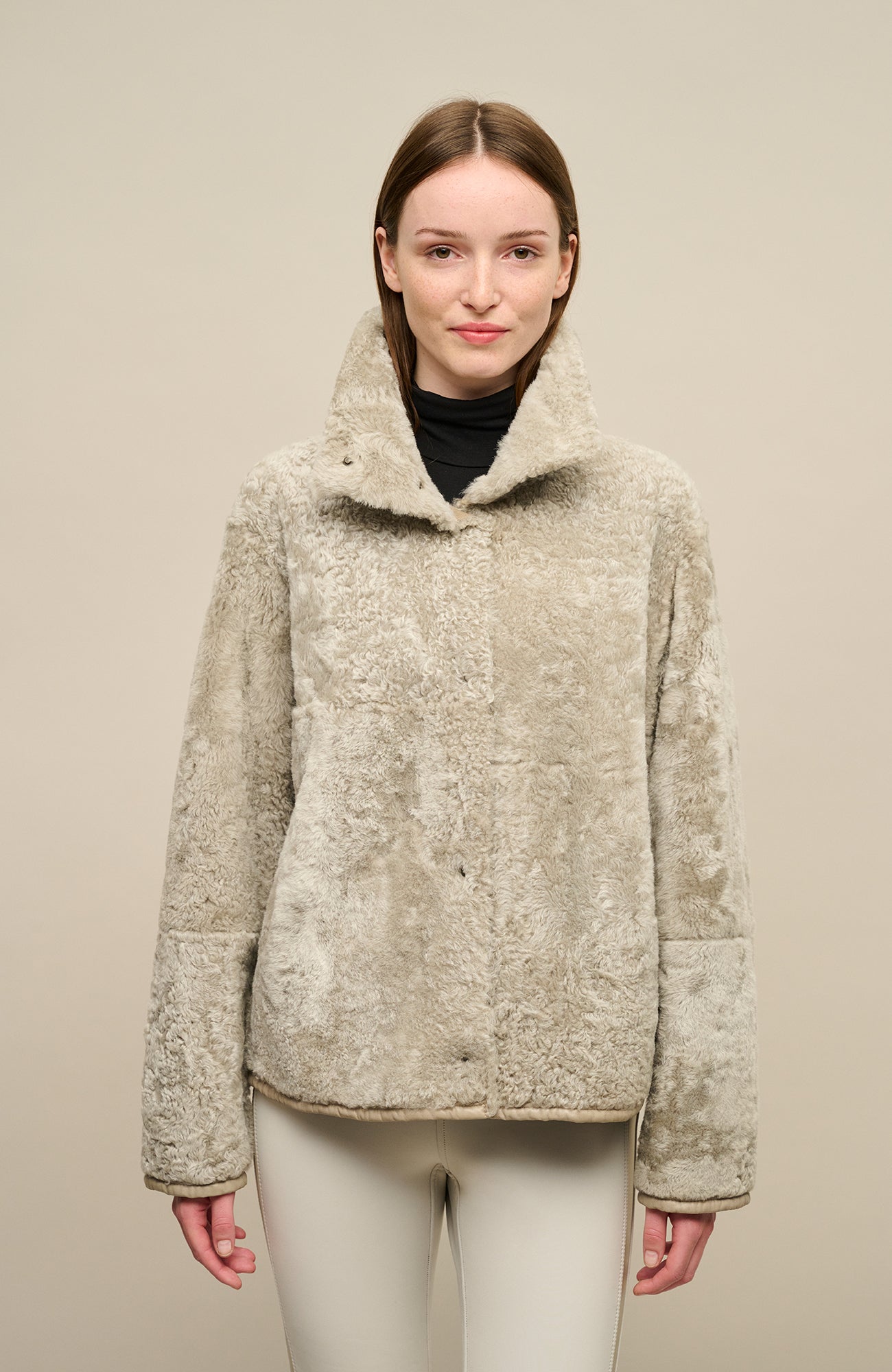 Damen Lammfellcape Modell Dolli in der Farbe savanna Modelansicht vorne – edles Cape aus weichem Lammfell mit fließendem Schnitt, stilvoll und wärmend für die kalte Jahreszeit.“