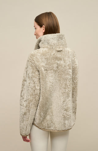 Damen Lammfellcape Modell Dolli in der Farbe savanna Model Rueckansicht  Fellseite– edles Cape aus weichem Lammfell mit fließendem Schnitt, stilvoll und wärmend für die kalte Jahreszeit.“