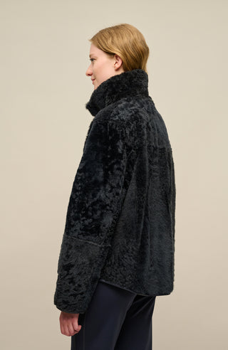 Damen Lammfellcape Modell Dolli in der Farbe midnight Model Rueckansicht – edles Cape aus weichem Lammfell mit fließendem Schnitt, stilvoll und wärmend für die kalte Jahreszeit.“