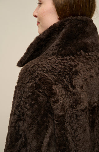 Damen Lammfellcape Modell Dolli in der Farbedunkelbraun Model Detailansicht – edles Cape aus weichem Lammfell mit fließendem Schnitt, stilvoll und wärmend für die kalte Jahreszeit.“