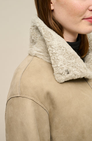 Damen Lammfellcape Modell Dolli in der Farbe sesame Model Detailansicht – edles Cape aus weichem Lammfell mit fließendem Schnitt, stilvoll und wärmend für die kalte Jahreszeit.“