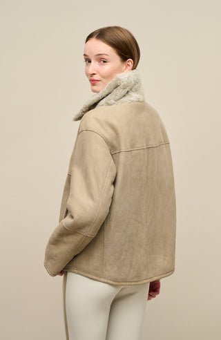 Damen Lammfellcape Modell Dolli in der Farbe sesame Model Rueckansicht – edles Cape aus weichem Lammfell mit fließendem Schnitt, stilvoll und wärmend für die kalte Jahreszeit.“
