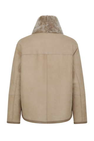 Damen Lammfellcape Modell Dolli in der Farbe sesame Rueckansicht – edles Cape aus weichem Lammfell mit fließendem Schnitt, stilvoll und wärmend für die kalte Jahreszeit.“