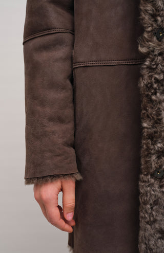 Damen Lammfellmantel mit Kapuze von Frauenschuh, Modell Olivera in der Farbe dunkelbraun Model Detailansicht– luxuriöser Wintermantel aus hochwertigem Lammfell für stilvolle Wärme.