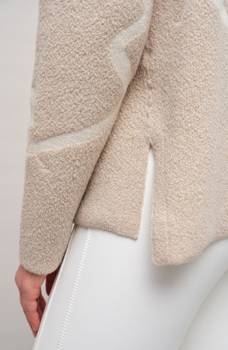 Vorderansicht eines Damenpullovers aus 100 % extrafeiner Merinowolle, Modell „Chatel-ME“ in der Farbe Beige. Die Vorderseite zeigt ein kunstvoll gestaltetes Jacquard-Motiv aus skizzierten Berglandschaften, urbanen Elementen und dynamischen Skifahrern. Das hochwertige Merinogarn – leicht, weich und angenehm auf der Haut – wird in Italien produziert und auf modernsten Maschinen verarbeitet. Die Kombination aus künstlerischem Design & technischer Strickkunst macht den Pullover besonders stilvoll