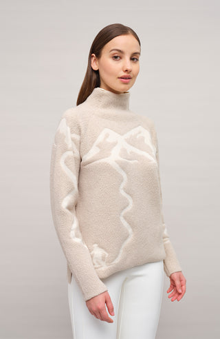 Vorderansicht eines Damenpullovers aus 100 % extrafeiner Merinowolle, Modell „Chatel-ME“ in der Farbe Beige. Die Vorderseite zeigt ein kunstvoll gestaltetes Jacquard-Motiv aus skizzierten Berglandschaften, urbanen Elementen und dynamischen Skifahrern. Das hochwertige Merinogarn – leicht, weich und angenehm auf der Haut – wird in Italien produziert und auf modernsten Maschinen verarbeitet. Die Kombination aus künstlerischem Design & technischer Strickkunst macht den Pullover besonders stilvoll