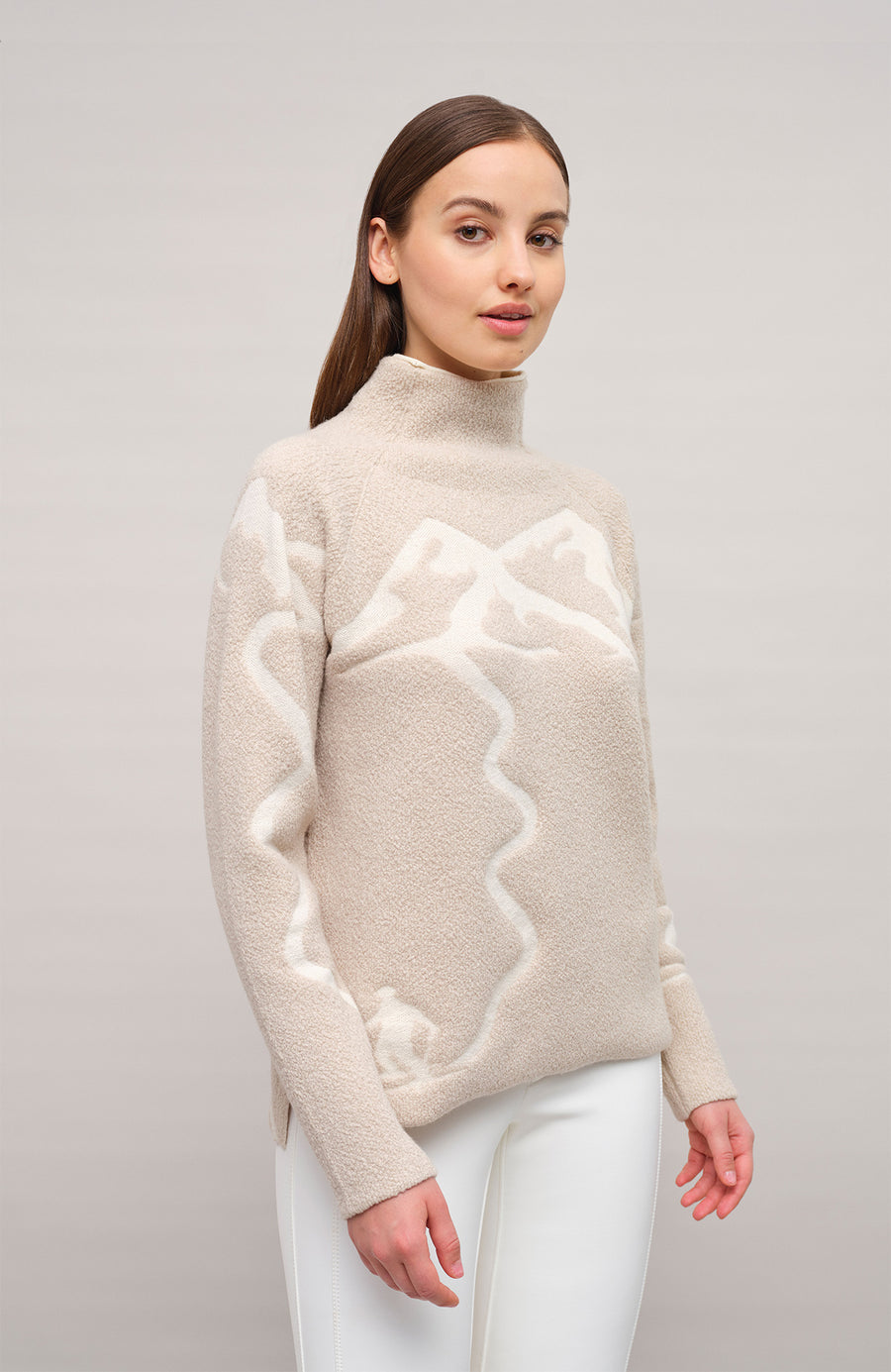 Vorderansicht eines Damenpullovers aus 100 % extrafeiner Merinowolle, Modell „Chatel-ME“ in der Farbe Beige. Die Vorderseite zeigt ein kunstvoll gestaltetes Jacquard-Motiv aus skizzierten Berglandschaften, urbanen Elementen und dynamischen Skifahrern. Das hochwertige Merinogarn – leicht, weich und angenehm auf der Haut – wird in Italien produziert und auf modernsten Maschinen verarbeitet. Die Kombination aus künstlerischem Design & technischer Strickkunst macht den Pullover besonders stilvoll
