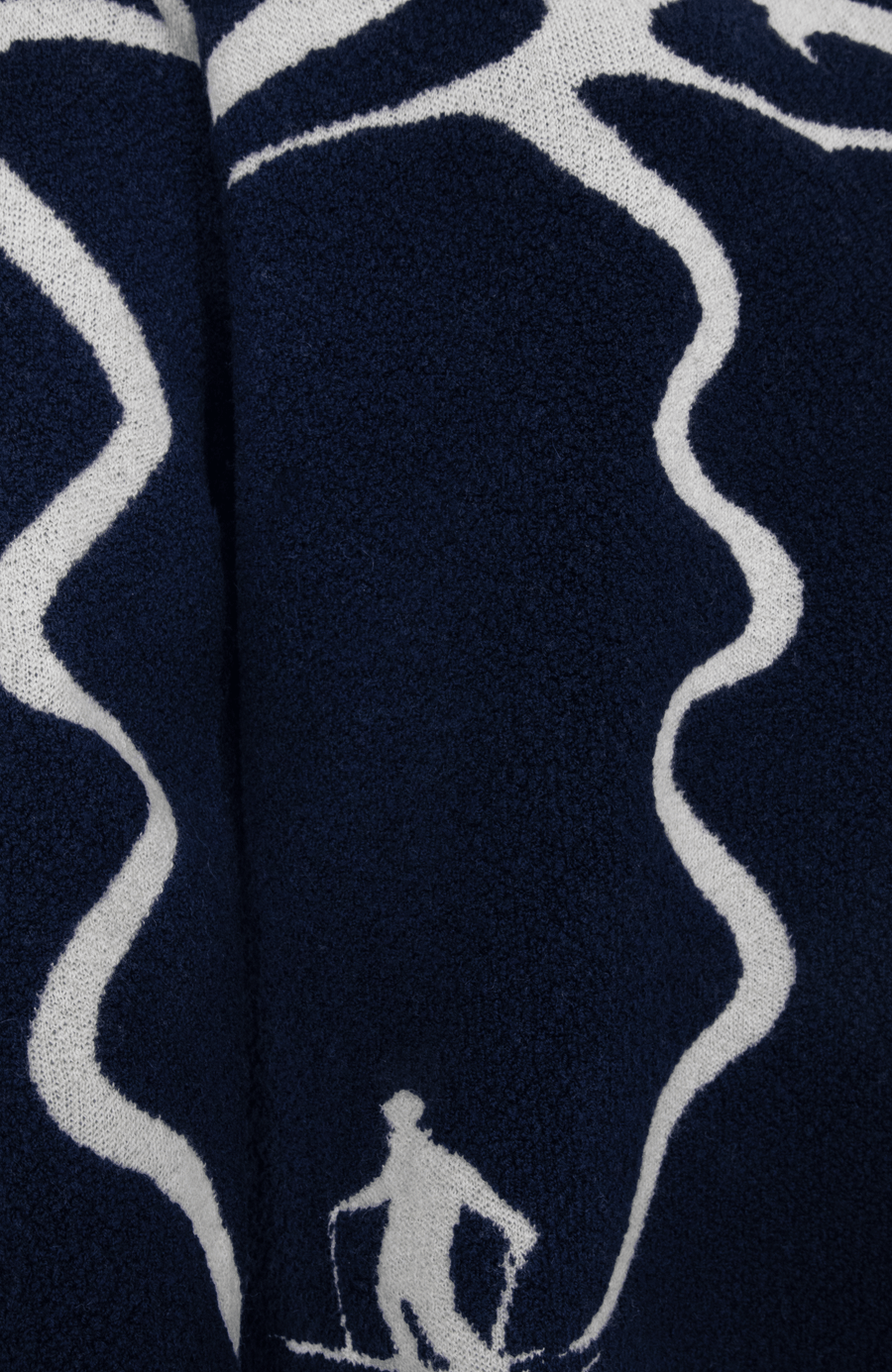 Detailansicht eines Damenpullovers aus 100 % extrafeiner Merinowolle, Modell „Chatel-ME“ in der Farbe Dunkelblau. Die Vorderseite zeigt ein kunstvoll gestaltetes Jacquard-Motiv aus skizzierten Berglandschaften, urbanen Elementen und dynamischen Skifahrern. Das hochwertige Merinogarn – leicht, weich und angenehm auf der Haut – wird in Italien produziert und auf modernsten Maschinen verarbeitet. Die Kombination aus künstlerischem Design & technischer Strickkunst macht den Pullover besonders stilvoll
