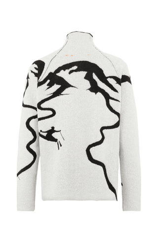 Rückansicht eines Damenpullovers aus 100 % extrafeiner Merinowolle, Modell „Chatel-ME“ in der Farbe Grau. Die Vorderseite zeigt ein kunstvoll gestaltetes Jacquard-Motiv aus skizzierten Berglandschaften, urbanen Elementen und dynamischen Skifahrern. Das hochwertige Merinogarn – leicht, weich und angenehm auf der Haut – wird in Italien produziert und auf modernsten Maschinen verarbeitet. Die Kombination aus künstlerischem Design & technischer Strickkunst macht den Pullover besonders stilvoll