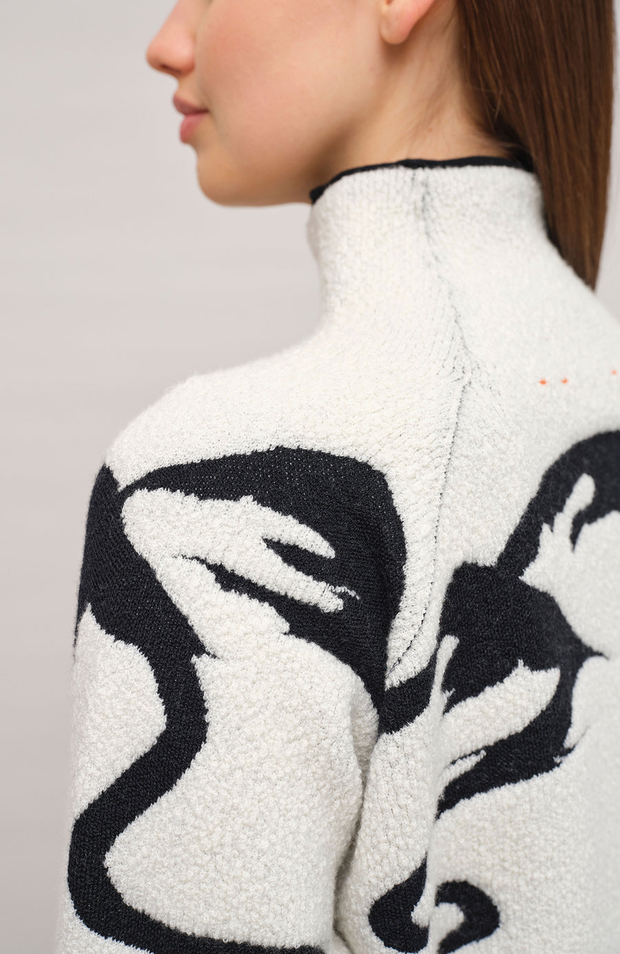 Vorderansicht eines Damenpullovers aus 100 % extrafeiner Merinowolle, Modell „Chatel-ME“ in der Farbe Grau. Die Vorderseite zeigt ein kunstvoll gestaltetes Jacquard-Motiv aus skizzierten Berglandschaften, urbanen Elementen und dynamischen Skifahrern. Das hochwertige Merinogarn – leicht, weich und angenehm auf der Haut – wird in Italien produziert und auf modernsten Maschinen verarbeitet. Die Kombination aus künstlerischem Design & technischer Strickkunst macht den Pullover besonders stilvoll