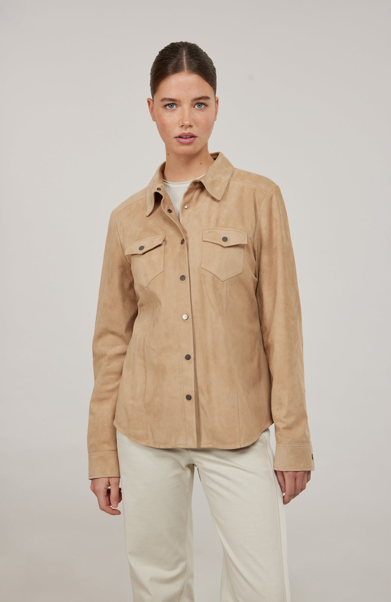 Western-Hemd Fanny-CA aus edlem Veloursleder, taillierte Passform, Druckknöpfe, abgerundeter Abschluss, zwei Brusttaschen und Knöpfe an den Ärmelabschlüssen. Weiches, anschmiegsames Material, das sich leicht an den Körper schmiegt. Farbe Hellbraun (Farbe: caramel).