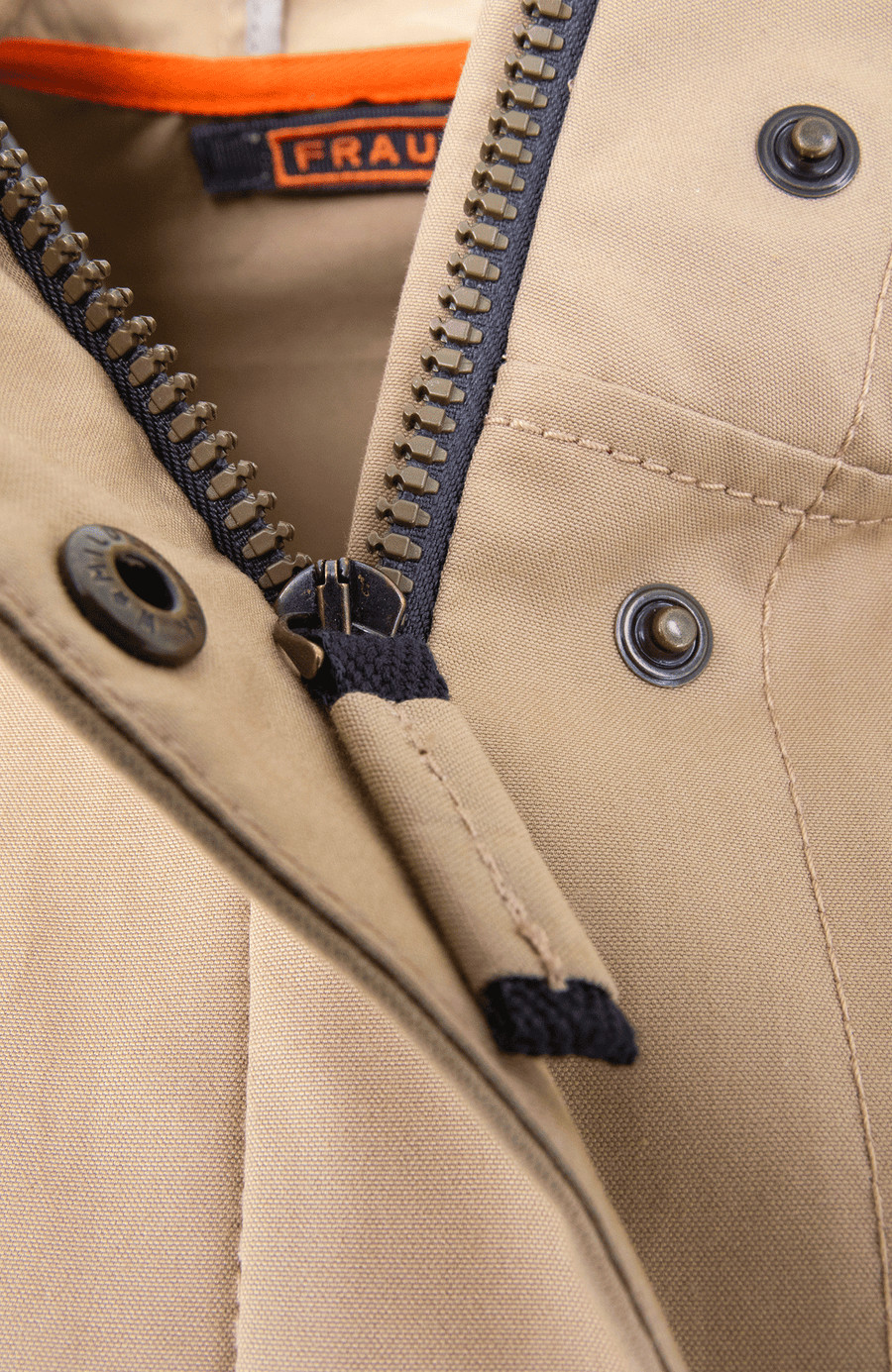 Damen-Knielanger Mantel aus Outdoor Cotton, wasser- und windabweisend, gerade Passform mit schmaler Silhouette, Stehkragen und weitenregulierbare Kapuze, Knopfleiste mit verdecktem Zwei-Wege-Zipper, Ripsband an Ärmelabschlüssen und Saum, seitliche Taschen mit markantem Zipper. In der Farbe Beige-Braun (Farbe: caramel).