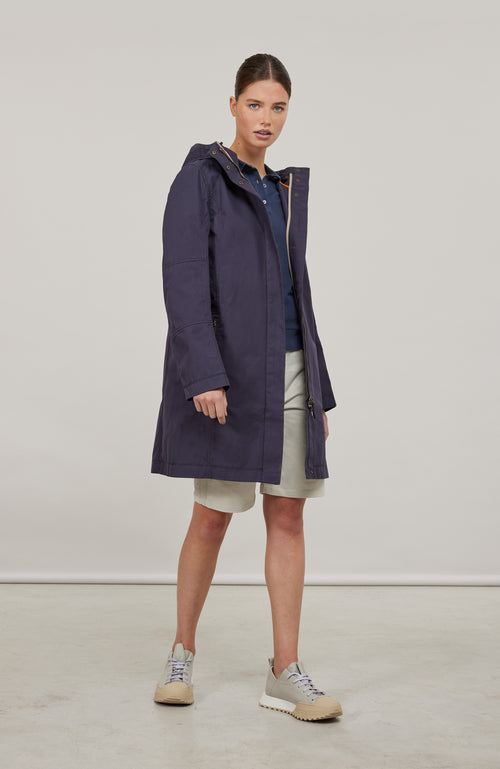 Damen-Knielanger Mantel aus Outdoor Cotton, wasser- und windabweisend, gerade Passform mit schmaler Silhouette, Stehkragen und weitenregulierbare Kapuze, Knopfleiste mit verdecktem Zwei-Wege-Zipper, Ripsband an Ärmelabschlüssen und Saum, seitliche Taschen mit markantem Zipper. In der Farbe Dunkelblau (Farbe: midnight).
