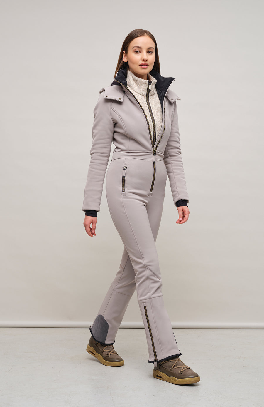 Performance Ski-Overall Kate-S aus Schöller Softshell, enganliegende Passform, Taillenbetonung durch angedeuteten Gürtel, abnehmbare Kapuze, Oberkörper gefüttert, markanter Zip, zwei Taschen mit markantem Zip, Skipasstasche mit nahtfeinem Zip, klassische Frauenschuh Features wie Kantenschutz aus Alcantara-Leder, enganliegende Ärmelbündchen und Schneefang. Robustes, elastisches Material, wasser- und windabweisend, ideal für die Skipiste. In der Farbe Hellbraun (Farbe: cashmere)