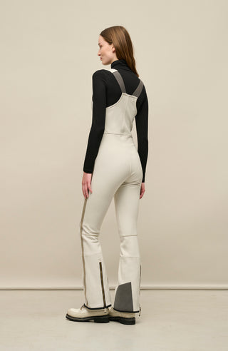 Ski-Catsuit Davina2.0-S im Latzhosen-Stil ohne Ärmel, schmaler figurbetonter Schnitt mit ausgestelltem Bein, femininer Bustier-Ausschnitt, Streifen an den Beinaußenseiten aus Alcantara-Leder, Träger hinten aus elastischem Gummi, ergonomisches Knie, markanter langer Zipper, auffallende Nähte, Seitentaschen mit Zip, Kantenschutz aus Alcantara-Leder und Schneefang. Enganliegend, feminin, betont Silhouette und Bewegungsfreiheit. In der Farbe Weiß-Beige (Farbe: sandstone)