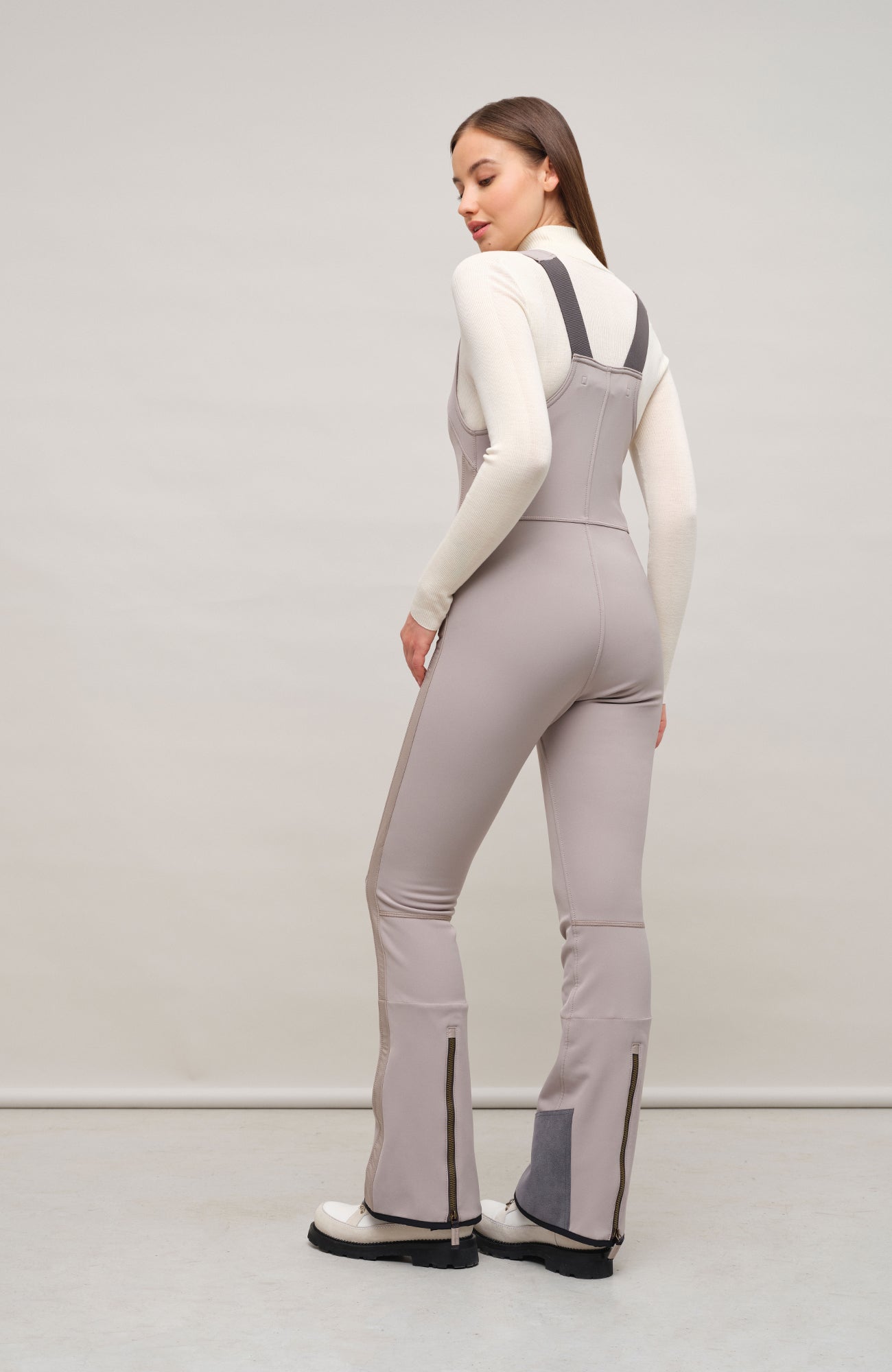 Ski-Catsuit Davina2.0-S im Latzhosen-Stil ohne Ärmel, schmaler figurbetonter Schnitt mit ausgestelltem Bein und femininer Bustier-Ausschnitt. Streifen an den Beinaußenseiten aus Alcantara-Leder, Träger hinten aus elastischem Gummi, ergonomisches Knie, langer Zipper, auffallende Nähte, Seitentaschen mit Zip, Kantenschutz aus Alcantara-Leder und Schneefang. Enganliegend und feminin, betont die Silhouette und Bewegungsfreiheit. In der Farbe Beige (Farbe: cashmere)