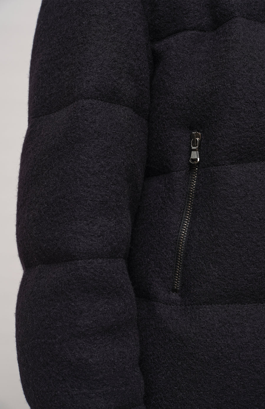 Winterjacke Alpine-LA aus innovativem Loden, mit Daunen gefüttert, etwas kürzer geschnitten. Quernähte als Designelement, Stehkragen, markanter Zwei-Wege-Zipper aus Metall, zwei Taschen mit Zip sowie zwei innenliegende Taschen. Beständiger Loden mit luxuriösem Griff. (Farbe: black)