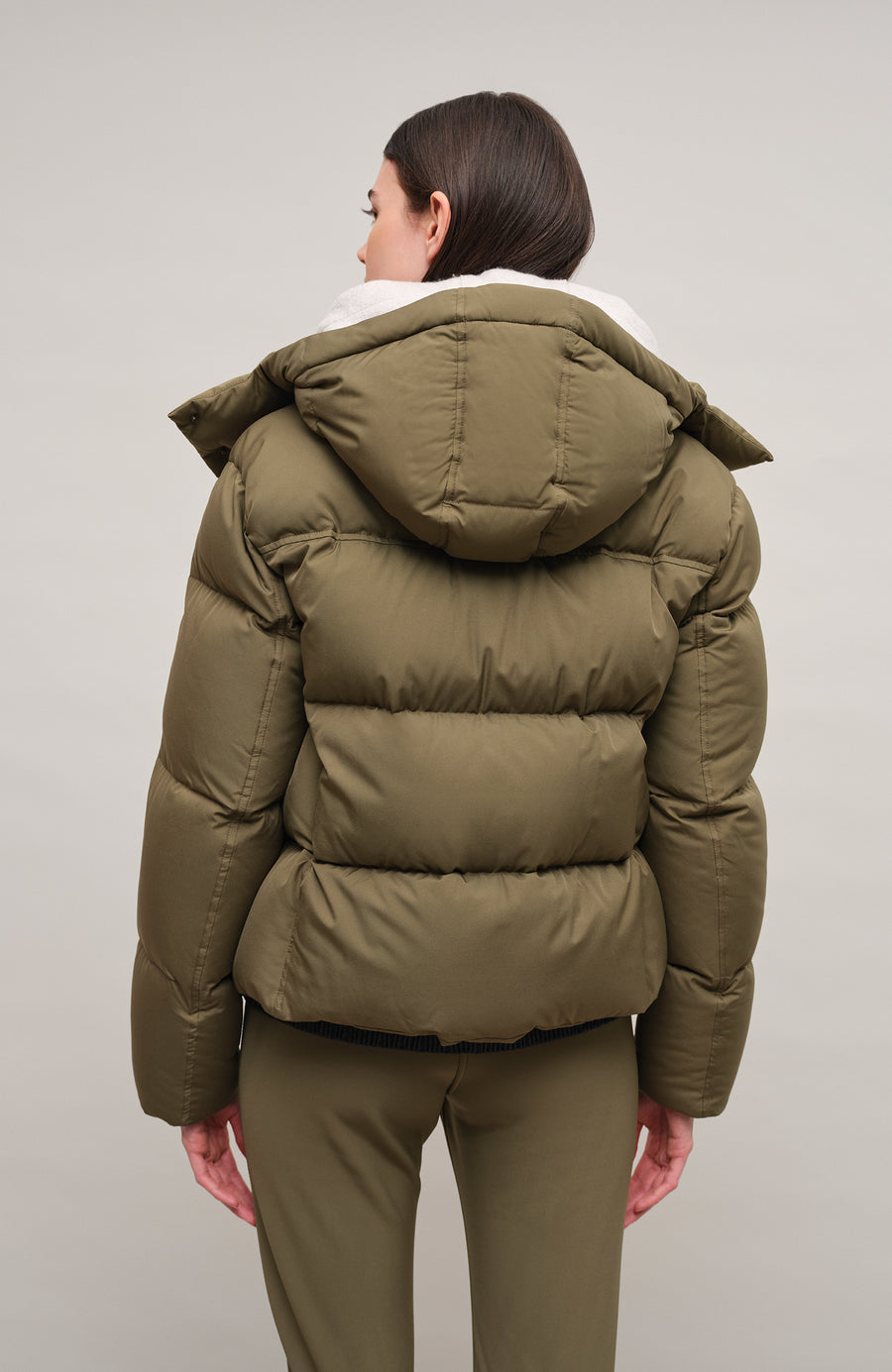 Winterjacke Isabel-LIN aus Light Italian Nylon, gerade Passform mit leicht verkürztem Schnitt, Kapuze mit innenliegendem Strickbündchen, Schneefang abnehmbar, gefüttert mit hochwertigen zertifizierten Daunen. Zwei versteckte Taschen, Zwei-Wege-Zipper, klassische Frauenschuh Features wie Schneefang an den Ärmeln, Skipasstasche und zwei innenliegende Taschen mit Zip. Seidig glänzende Oberfläche, funktional und warm. In der Farbe Dunkelgrün (Farbe: ivy)