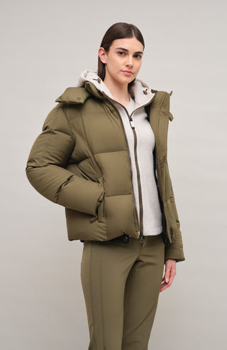 Winterjacke Isabel-LIN aus Light Italian Nylon, gerade Passform mit leicht verkürztem Schnitt, Kapuze mit innenliegendem Strickbündchen, Schneefang abnehmbar, gefüttert mit hochwertigen zertifizierten Daunen. Zwei versteckte Taschen, Zwei-Wege-Zipper, klassische Frauenschuh Features wie Schneefang an den Ärmeln, Skipasstasche und zwei innenliegende Taschen mit Zip. Seidig glänzende Oberfläche, funktional und warm. In der Farbe Dunkelgrün (Farbe: ivy)